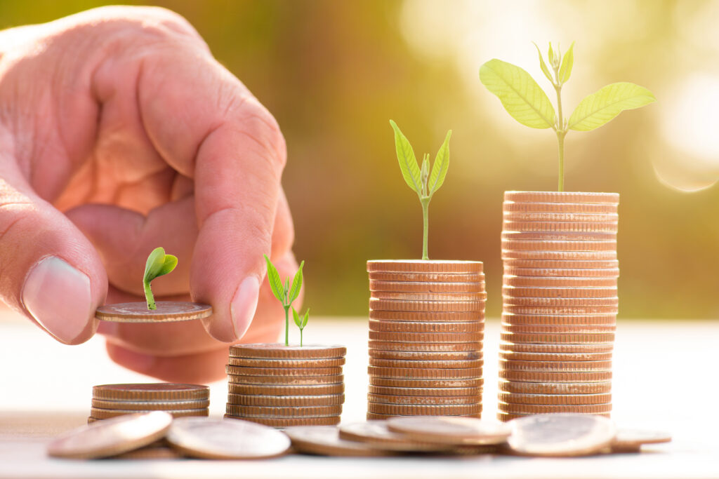 Close up of male hand stacking gold coins with green bokeh background Business Finance and Money conceptSave money for prepare in the futureTrees growing on coin - Trade Info pripojestenie, dôchod