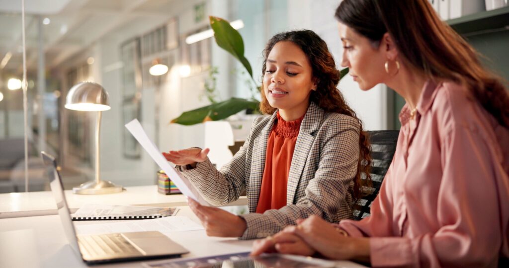 Planning reading and financial advisor with client for document investment discussion and tips Business office women team and talking with paperwork for policy review laptop or corporate meeting - Trade Info Buy & Hold, stratégia, investorov
