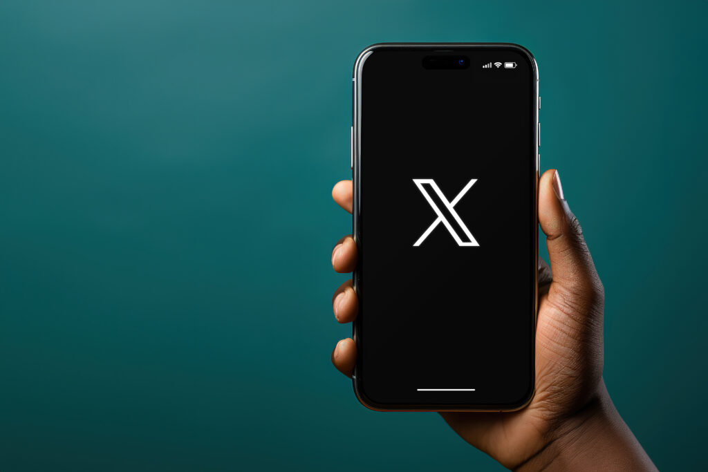 Black hand holding a smartphone iPhone with X new Twitter social media app on the screen White background Rio de Janeiro RJ Brazil July 24 2023 - Trade Info X, blockchain