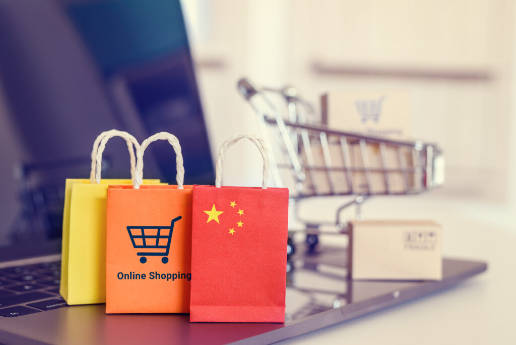 Online shopping home shopping or product ordering ecommerce concept Flag of China shopping bag with a shopping cart on a laptop keyboard depicting buyer buys goods or services via the internet - Trade Info Čínske ceny