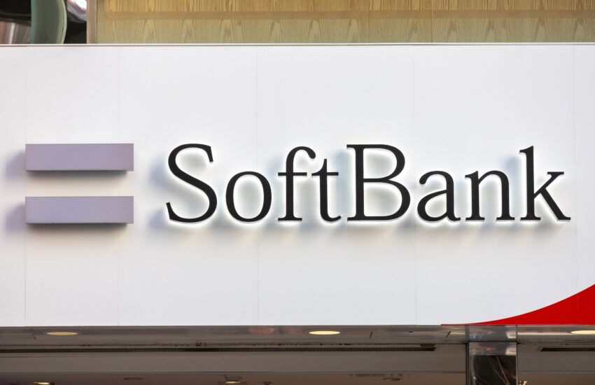 Close-up of a large SoftBank sign on a white wall with partial purple shelves on the left.